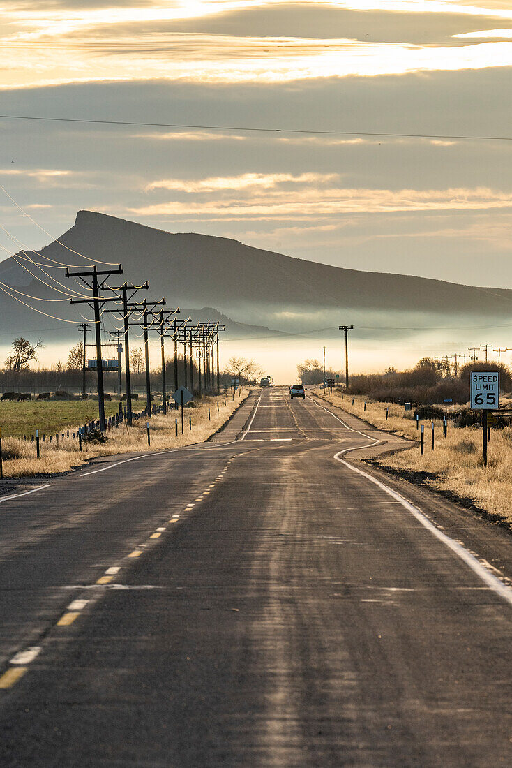 USA, Idaho, Bellevue, Rural road with mountain and morning mist in distance