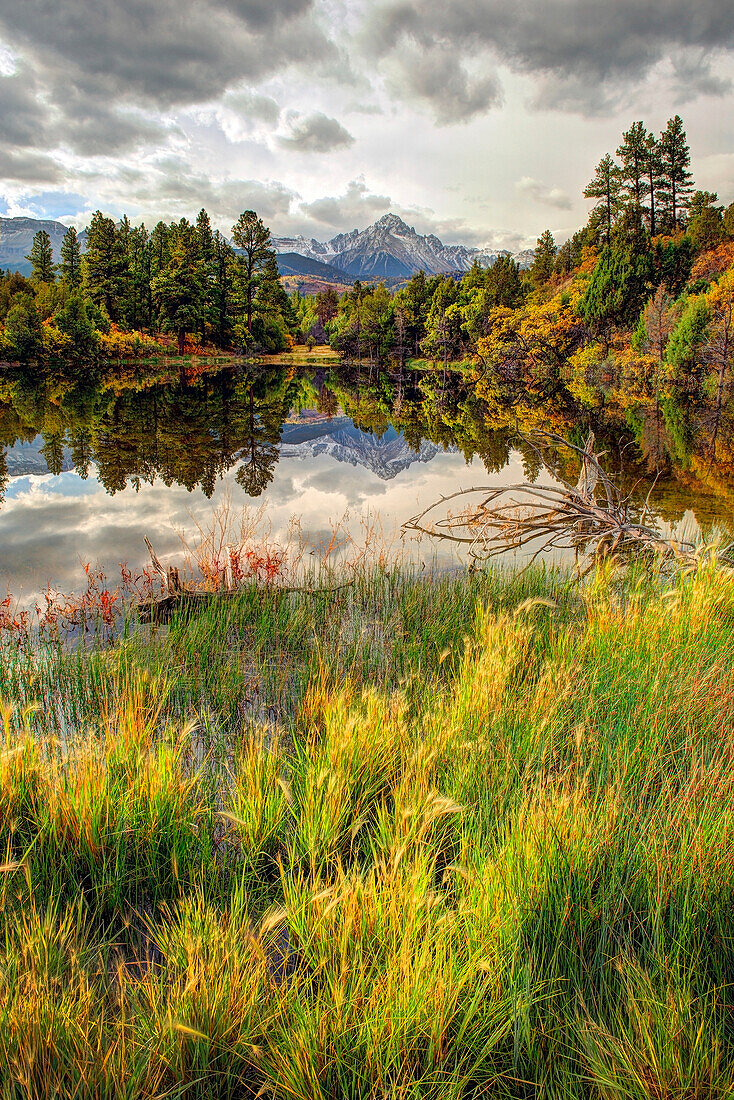 Mt. Snaffles is reflected in an autumn pond of color in the Colorado Rocky Mountains