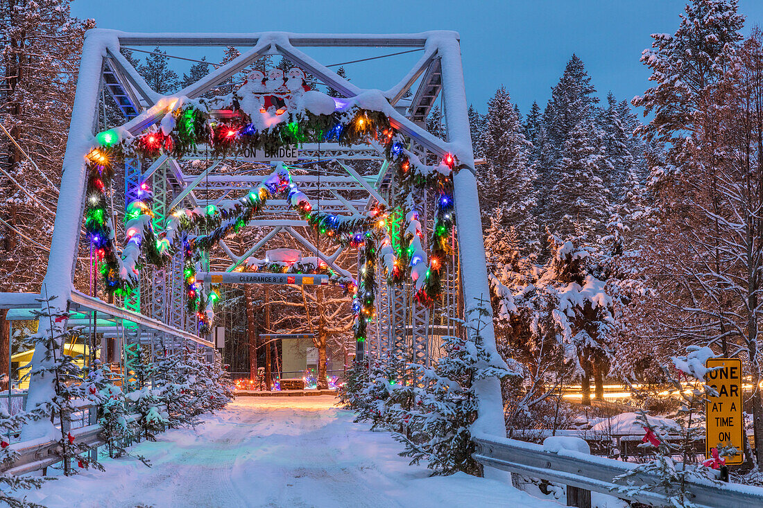 Christmas decorations adorn the historic one lane Swan River Bridge in Bigfork, Montana, USA