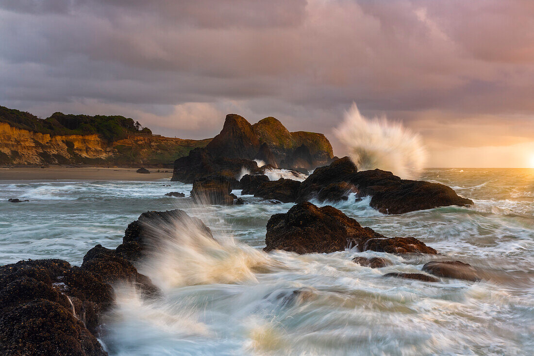 Große Wellen, die gegen das Meer krachen, stapeln sich am Strand von Seal Rock.