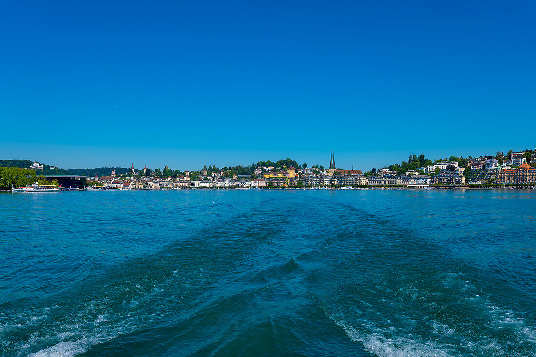 Rückansicht von einem Motorboot mit Stadtbild und Vierwaldstättersee an einem sonnigen Sommertag in Luzern, Schweiz.
