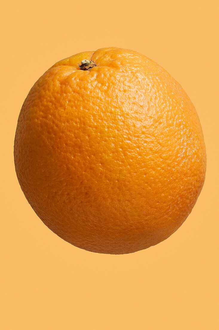 Close up dimples on vibrant, whole orange