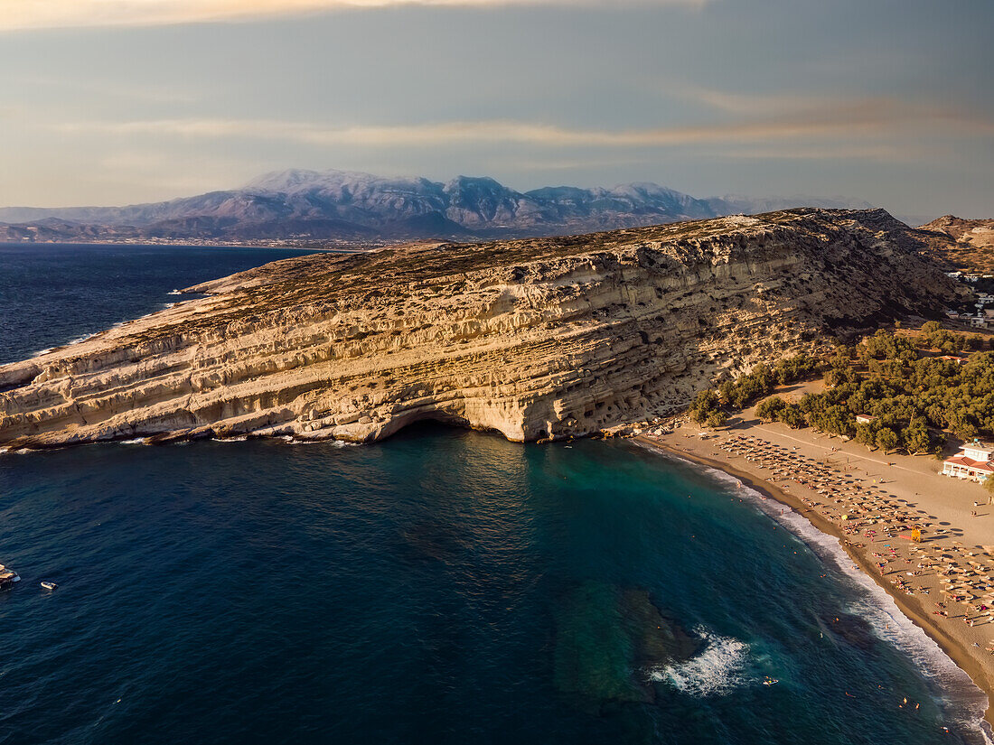 Drohnenansicht der künstlichen Höhlen von Matala auf dem Felsen am Strand von Kreta, griechische Inseln, Griechenland, Europa