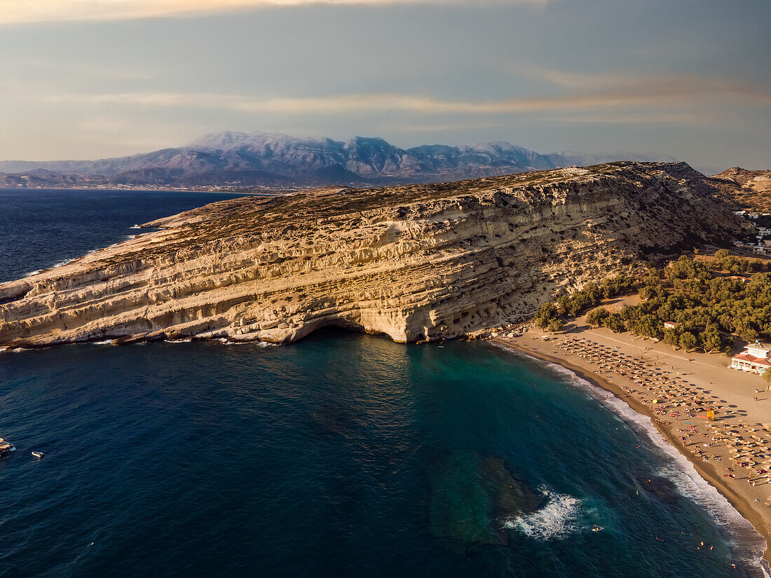 Drone view of Matala artificial caves on the rock by the beach at Crete, Greek Islands, Greece, Europe