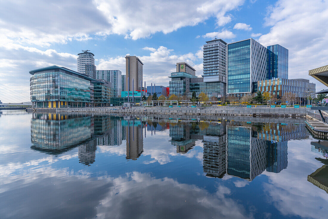 View of MediaCity and clouds reflecting in water in Salford Quays, Manchester, England, United Kingdom, Europe