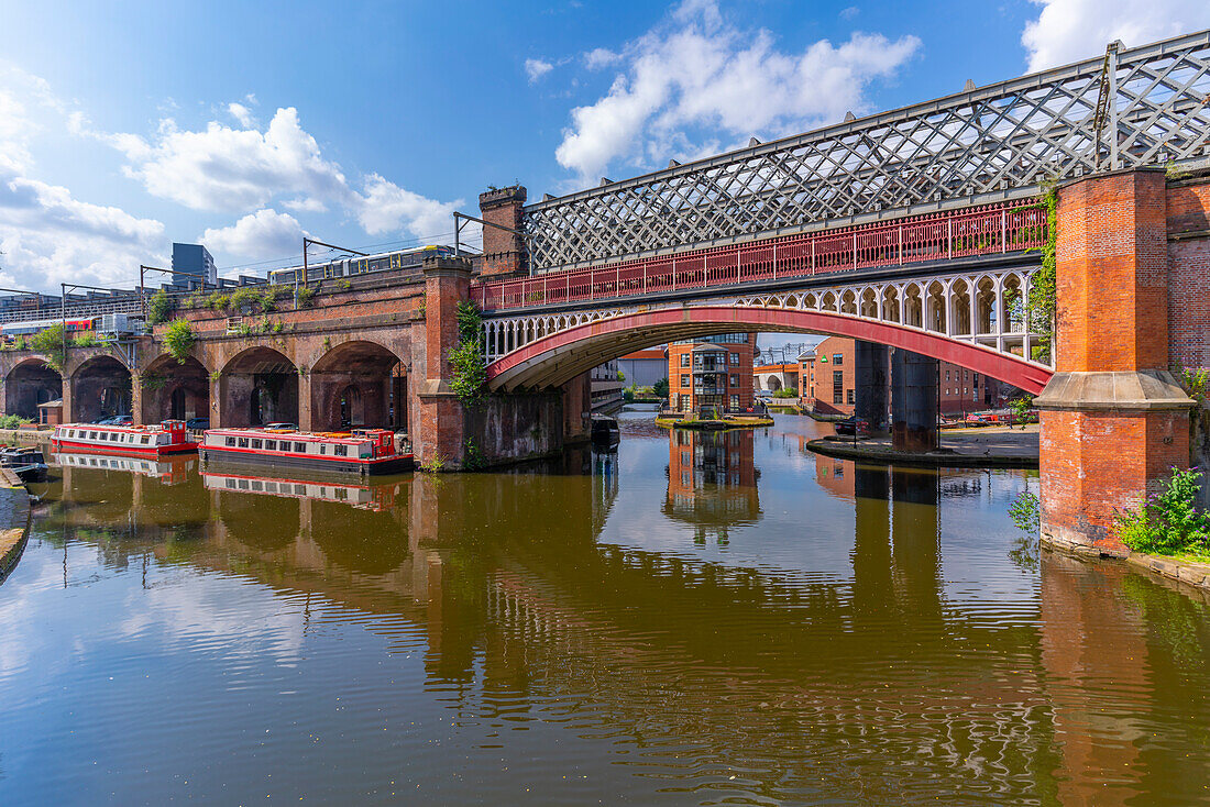 Blick auf Straßenbahn- und Zugbrücken, die sich im Castlefield Canal, Castlefield, Manchester, England, Vereinigtes Königreich, Europa widerspiegeln