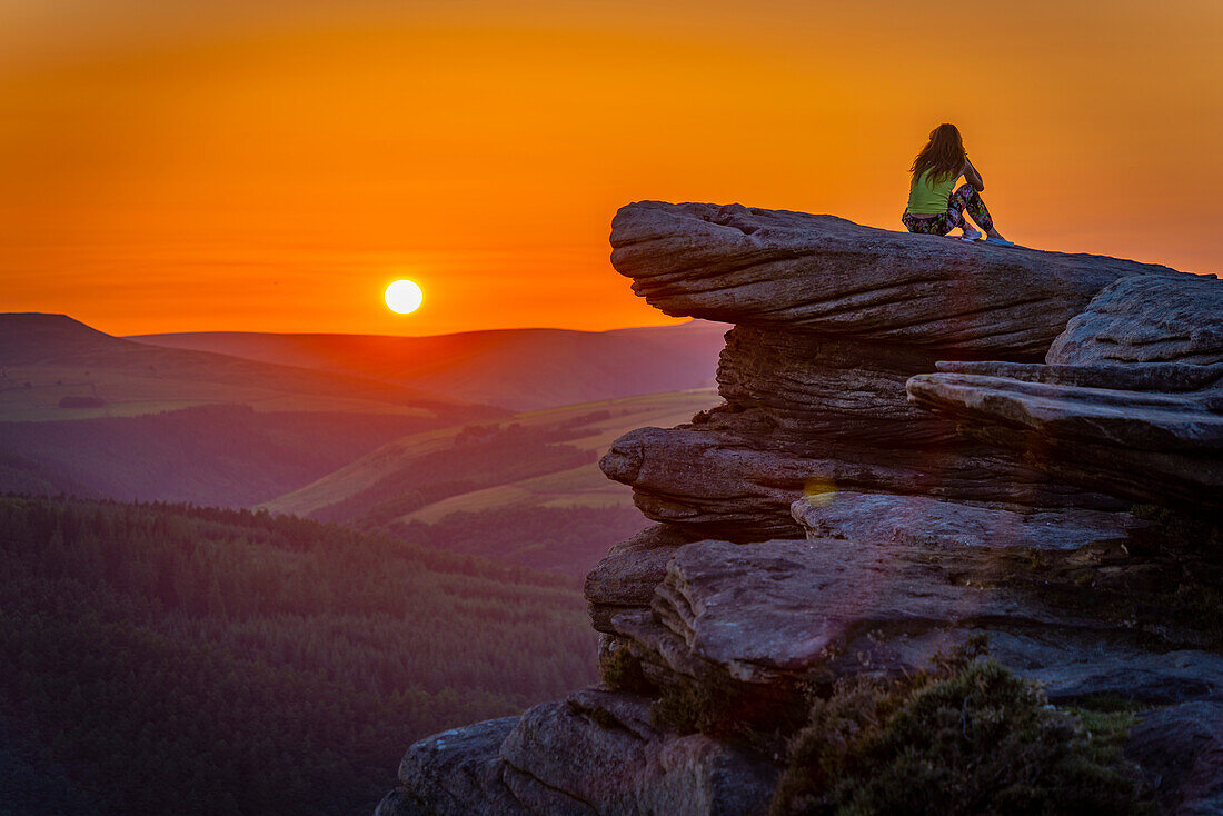 Ansicht der jungen Frau auf Bamford Edge bei Sonnenuntergang, Bamford, Nationalpark Peak District, Derbyshire, England, Vereinigtes Königreich, Europa