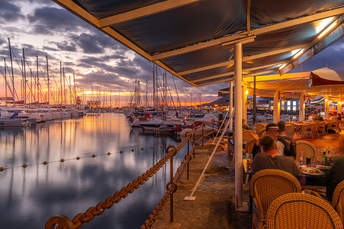 Blick auf Boote und Einkaufszentrum Marina Rubicon vom Restaurant bei Sonnenuntergang, Playa Blanca, Lanzarote, Kanarische Inseln, Spanien, Atlantik, Europa