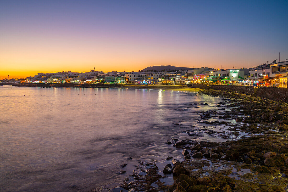 Blick auf Strand und Cafés und Bars in der Abenddämmerung, Playa Blanca, Lanzarote, Kanarische Inseln, Spanien, Atlantik, Europa