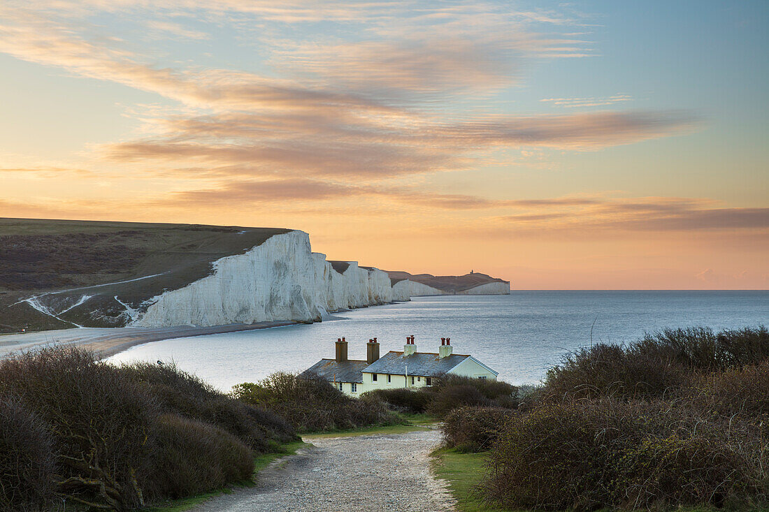 Seven Sisters und Beachy Head mit Cottages der Küstenwache bei Sonnenaufgang im Frühjahr, Seaford Head, East Sussex, England, Vereinigtes Königreich, Europa