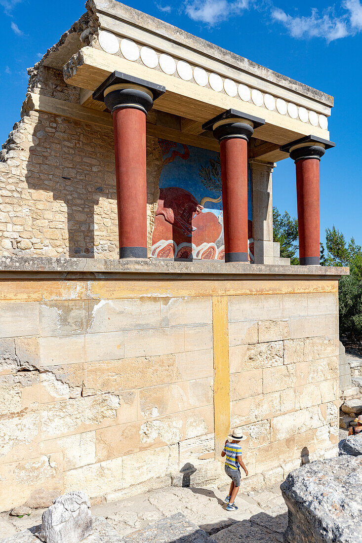 Kleiner Junge, der die archäologische Stätte von Knossos und die Ruinen des minoischen Palastes, Knossos, Heraklion, Kreta, griechische Inseln, Griechenland, Europa erkundet