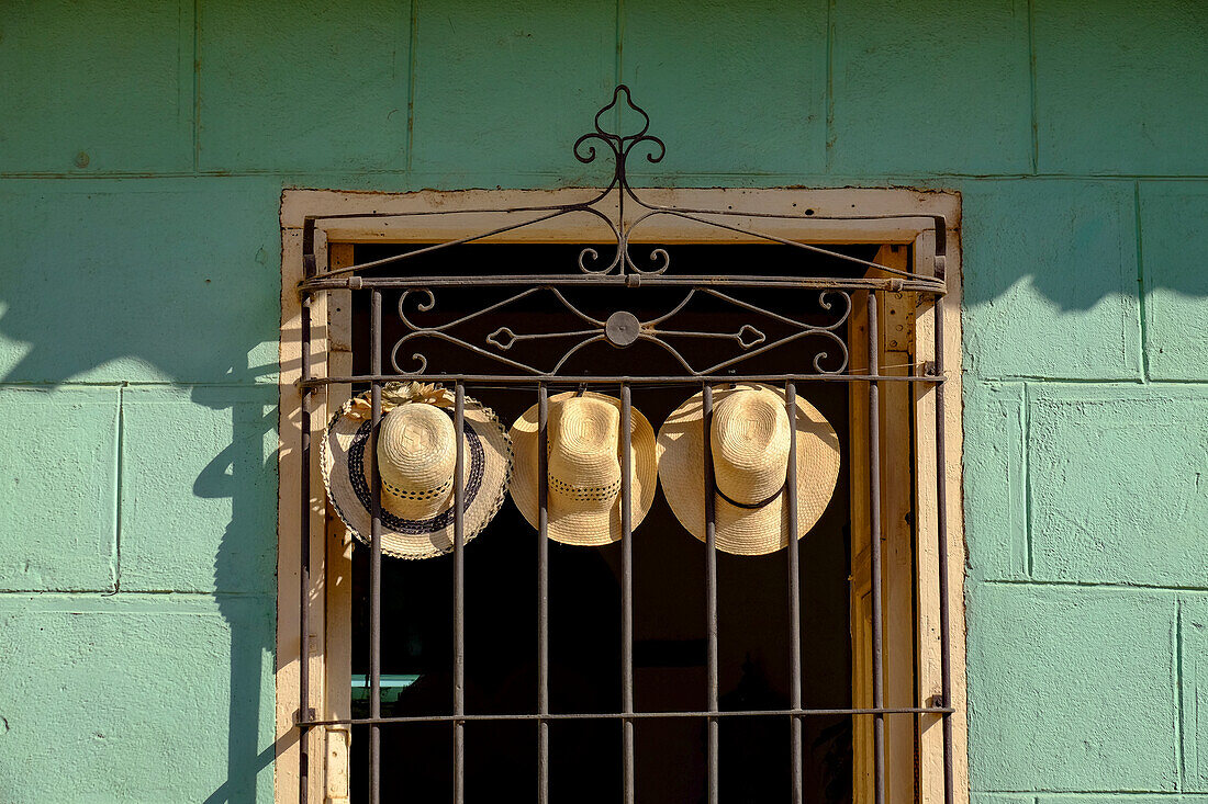 Drei Strohhüte hängen an einem Eisengitter in einem Fenster, Trinidad, Kuba, Westindien, Mittelamerika