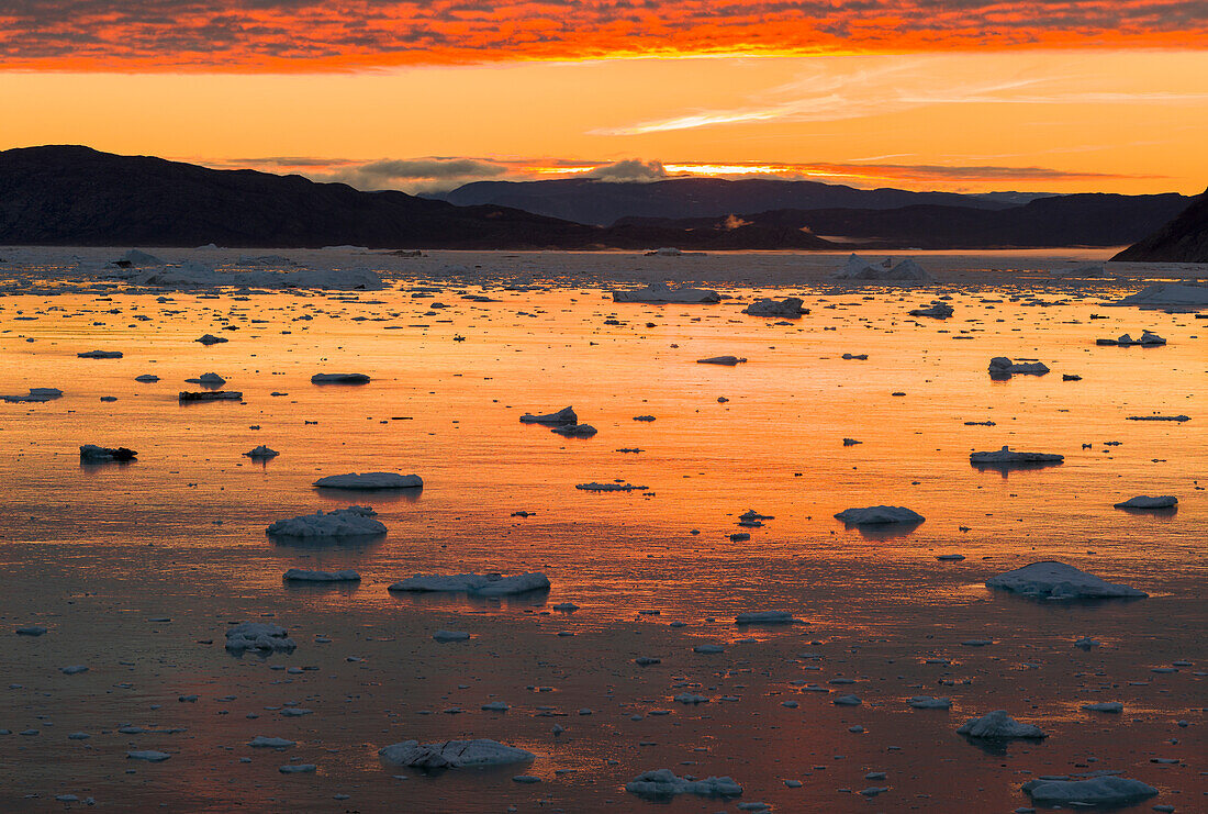 Sonnenuntergang über dem Fjord mit Eisbergen in der Nähe des Gletschers Eqip Sermia in Dänemarks Überseegebiet, Grönland.