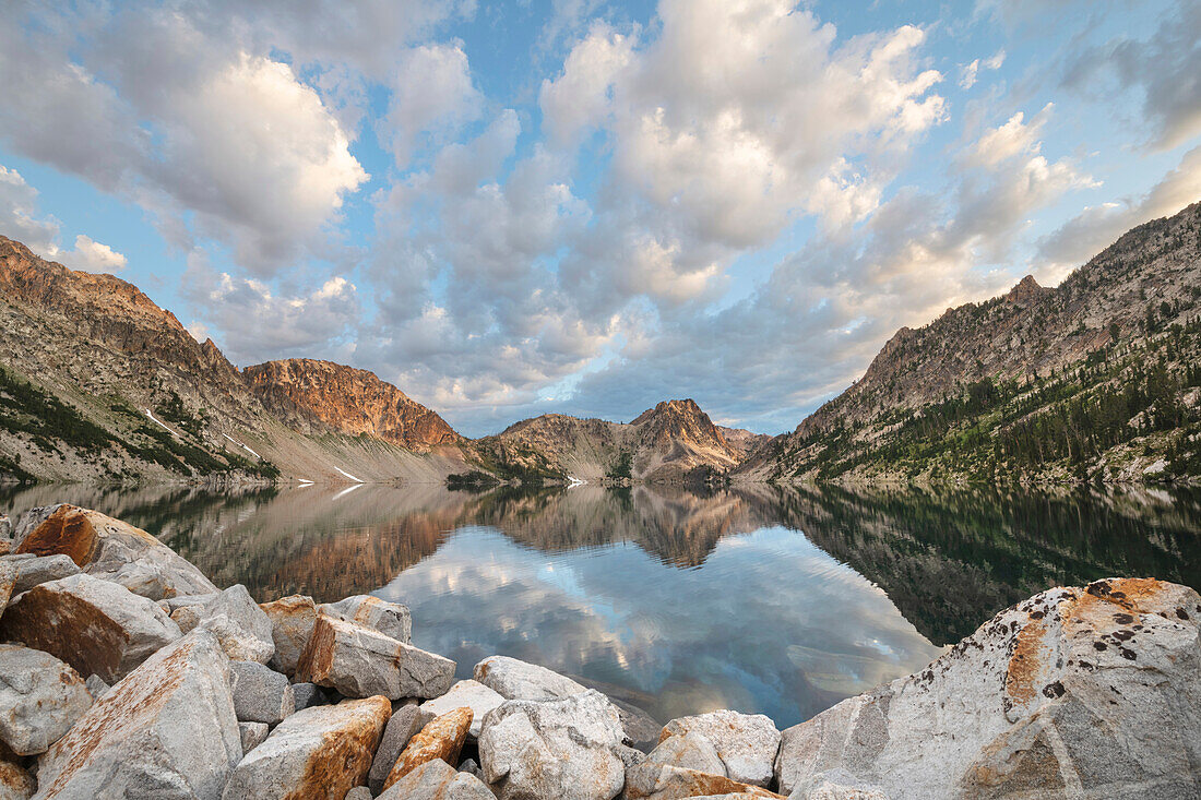 Morning clouds mirrored in still waters of Sawtooth Lake, Sawtooth Mountains Wilderness, Idaho.
