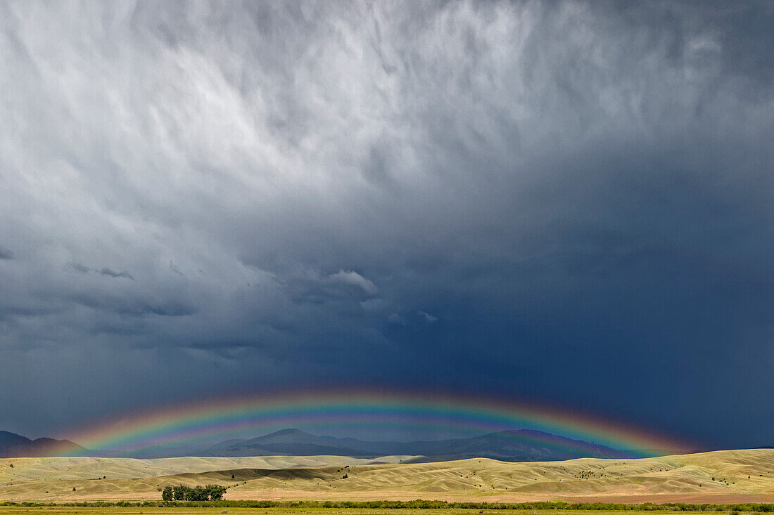 USA, Montana. Rainbow over stormy landscape