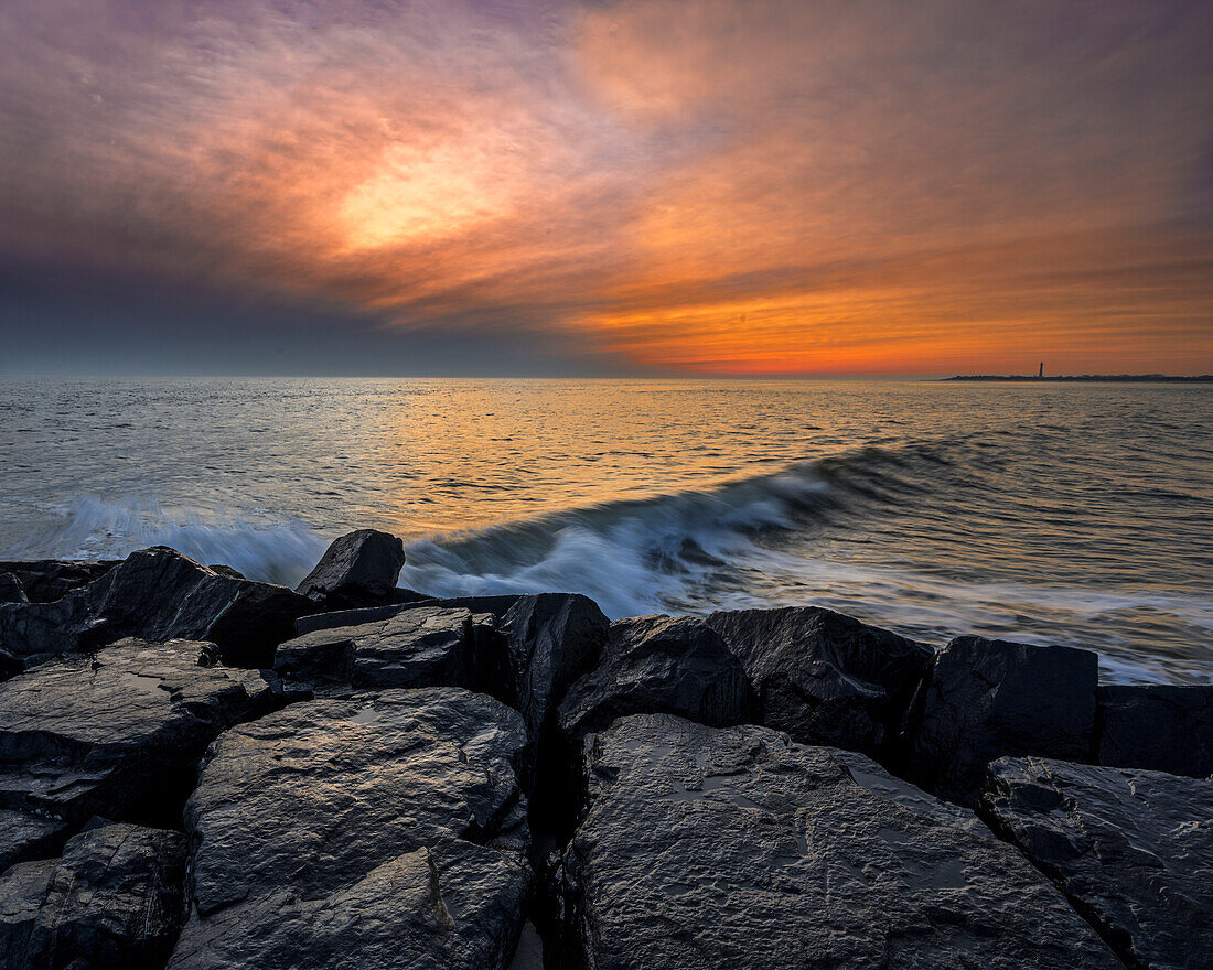 USA, New Jersey, Cape May National Seashore. Sunset on ocean and rocks