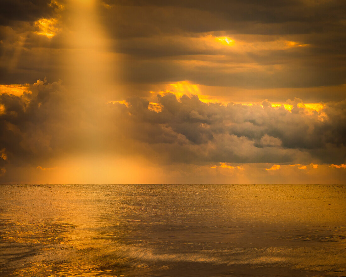 USA, New Jersey, Cape May National Seashore. Sonnenlicht durch Gewitterwolken über dem Ozean.