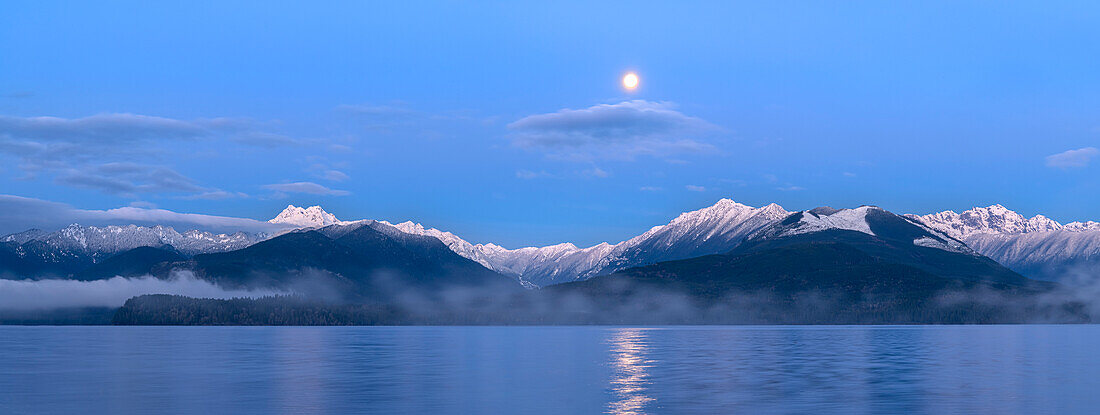 USA, Washington State, Seabeck. Panoramic of moon setting over Olympic Mountains and Hood Canal.