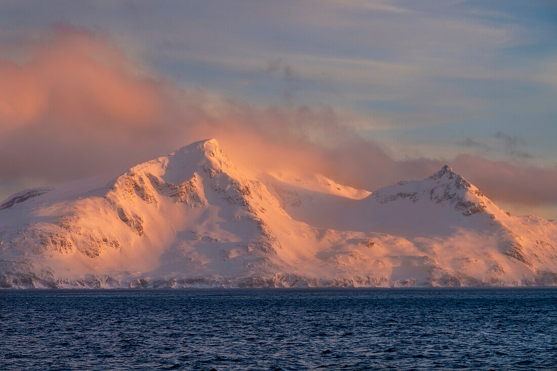 Antarktis, Südgeorgien Insel, Bay of Isles. Sonnenaufgang über Berg und Meer.