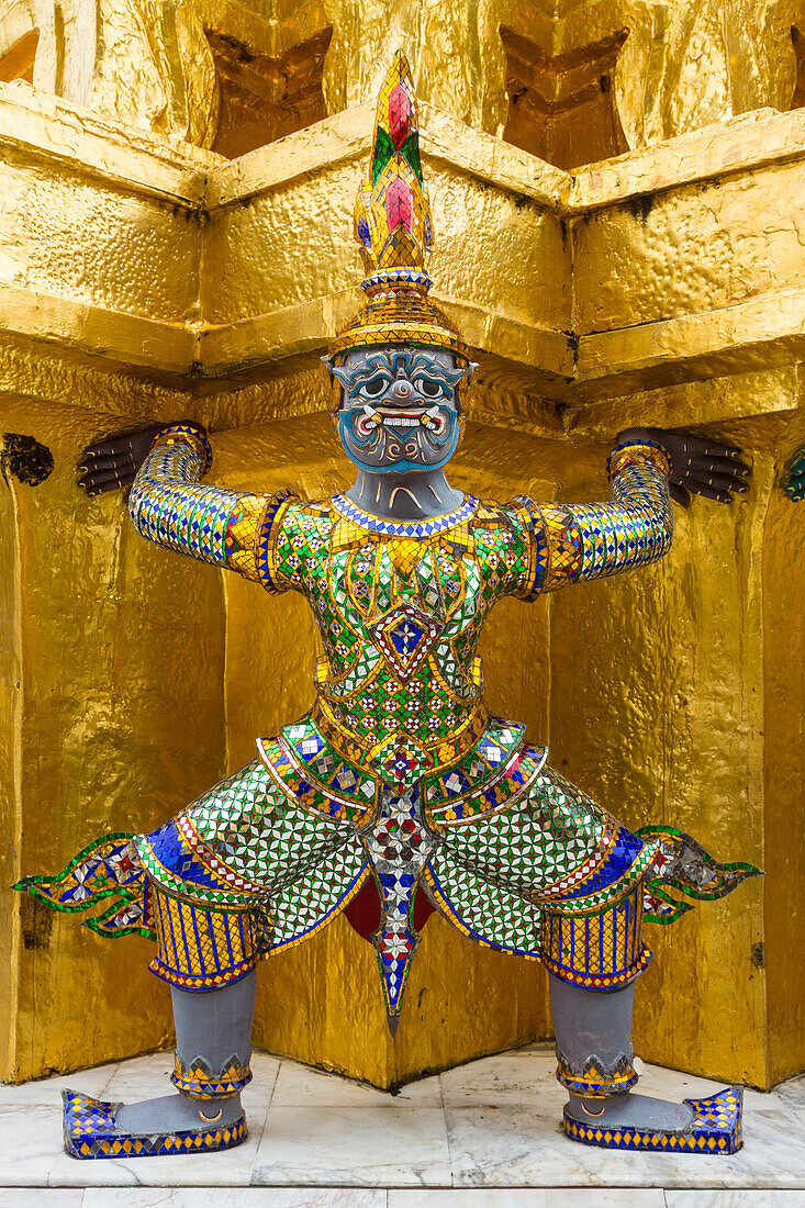 Thailand, Bangkok.Yaksha (Dämonen) bewachen einen der goldenen Chedi im Wat Phra Kaew.