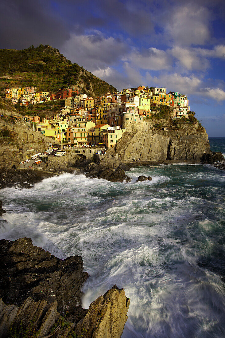 Wirbelndes Meer am Fuße der mittelalterlichen Stadt Manarola in den Cinque Terre, Ligurien, Italien