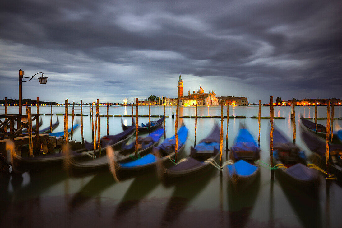 Italy, Venice. Moored gondolas and Church of San Giorgio Maggiore at sunrise.