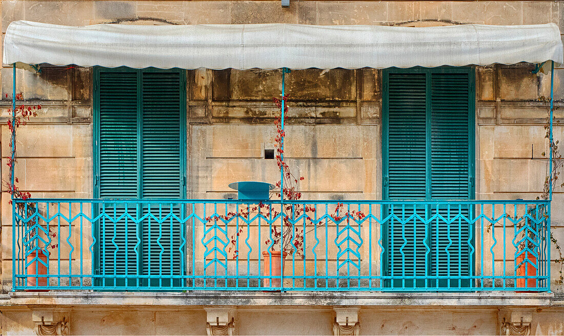 Italien, Apulien, Brindisi, Itria-Tal, Ostuni. Doppelte türkisfarbene Fensterläden und Geländer eines Hauses in der malerischen Altstadt von Ostuni.