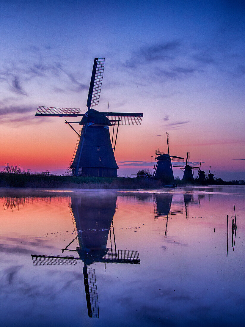 Europa; Niederlande; Kinderdijk; Sonnenaufgang entlang des Kanals mit Windmühlen