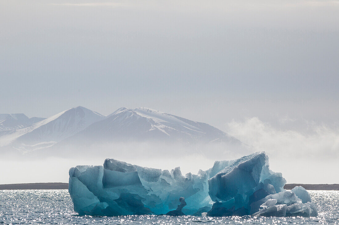 Europe, Norway, Svalbard. Backlit blue glacial ice.