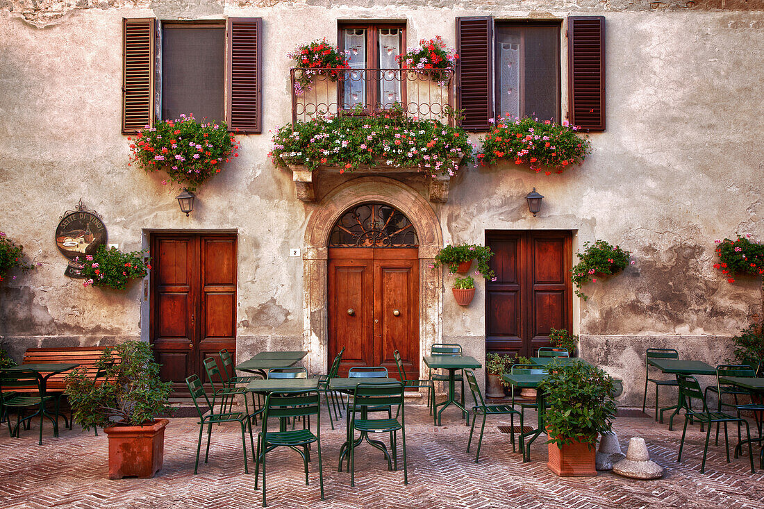 Italien, Toskana, Pienza. Tische und Stühle, die für ein Essen im Freien in der Stadt Pienza aufgestellt sind.