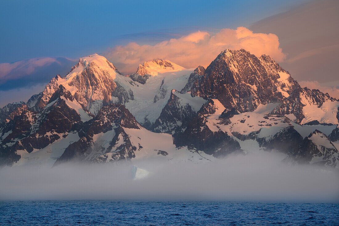 Antarctica, South Georgia Island, Coopers Bay. Iceberg and mountains at sunrise