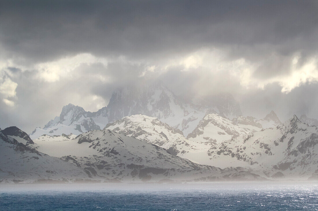 Antarktis, Insel Südgeorgien, Coopers Bay. Gewitterwolken über Bergen