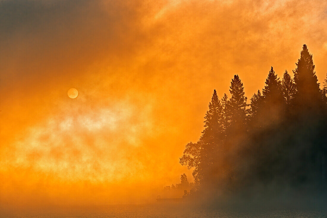 Canada, Manitoba, Whiteshell Provincial Park. Foggy sunrise over Caddy Lake.
