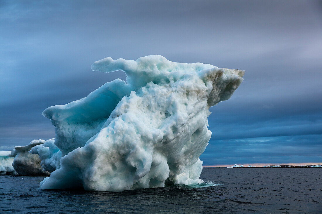 Canada, Nunavut Territory, Repulse Bay, Melting iceberg grounded in Harbor Islands on summer evening