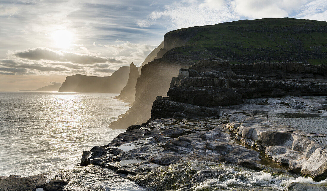 Die Westküste in der Nähe von Traelanipa mit Wasserfall Bosdalafossur bei Sonnenuntergang. Insel Vagar, Teil der Färöer-Inseln im Nordatlantik. Dänemark