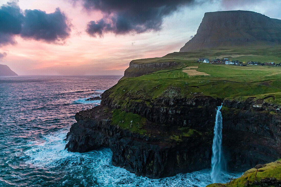 Europa, Färöer. Blick auf das Dorf Gasadalur und den Mulafossur-Wasserfall auf der Insel Vagar.