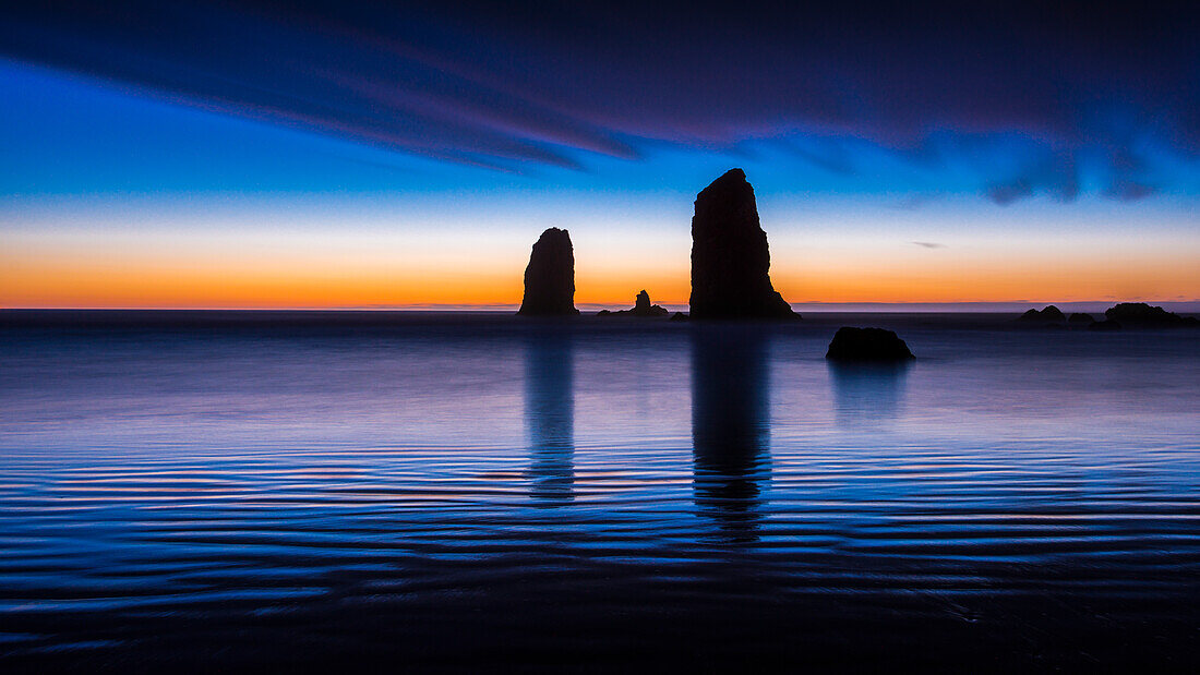 USA, Oregon, Cannon Beach, Seastack Reflexion bei Sonnenuntergang.