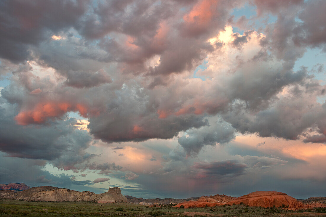 USA, Utah. Landschaft mit Sandsteinformationen und klaren Gewitterwolken bei Sonnenuntergang.