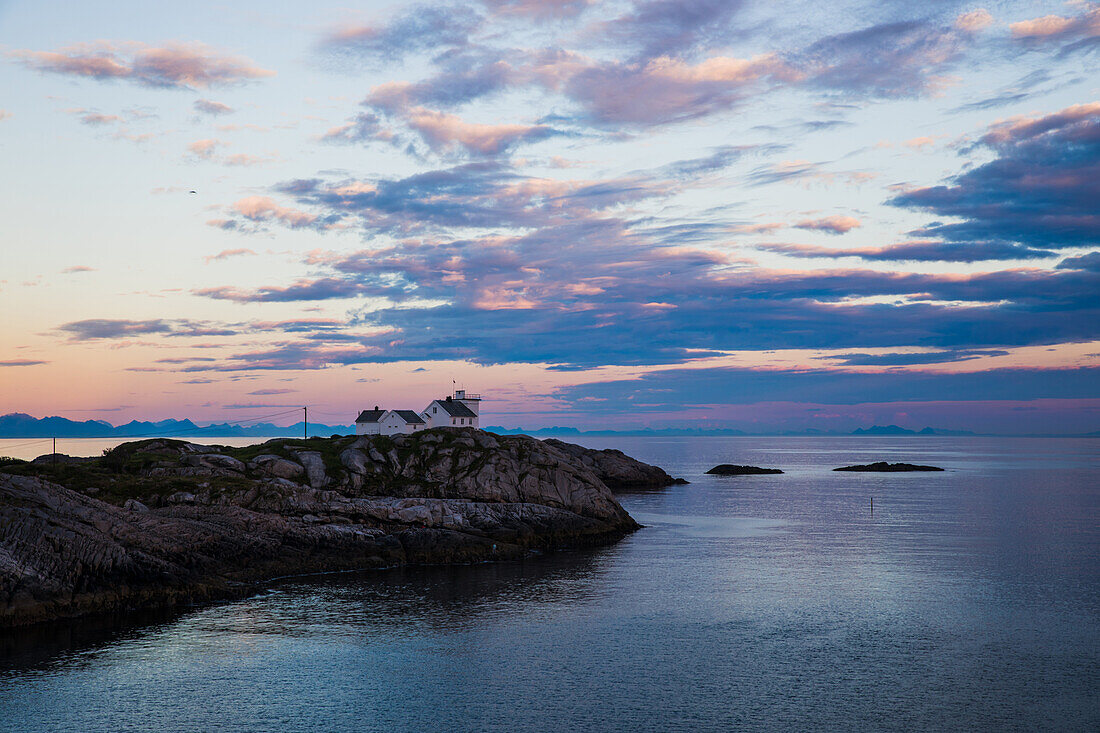 Norwegen, Lofoten, Leuchtturm im Sonnenuntergang über dem Fjord