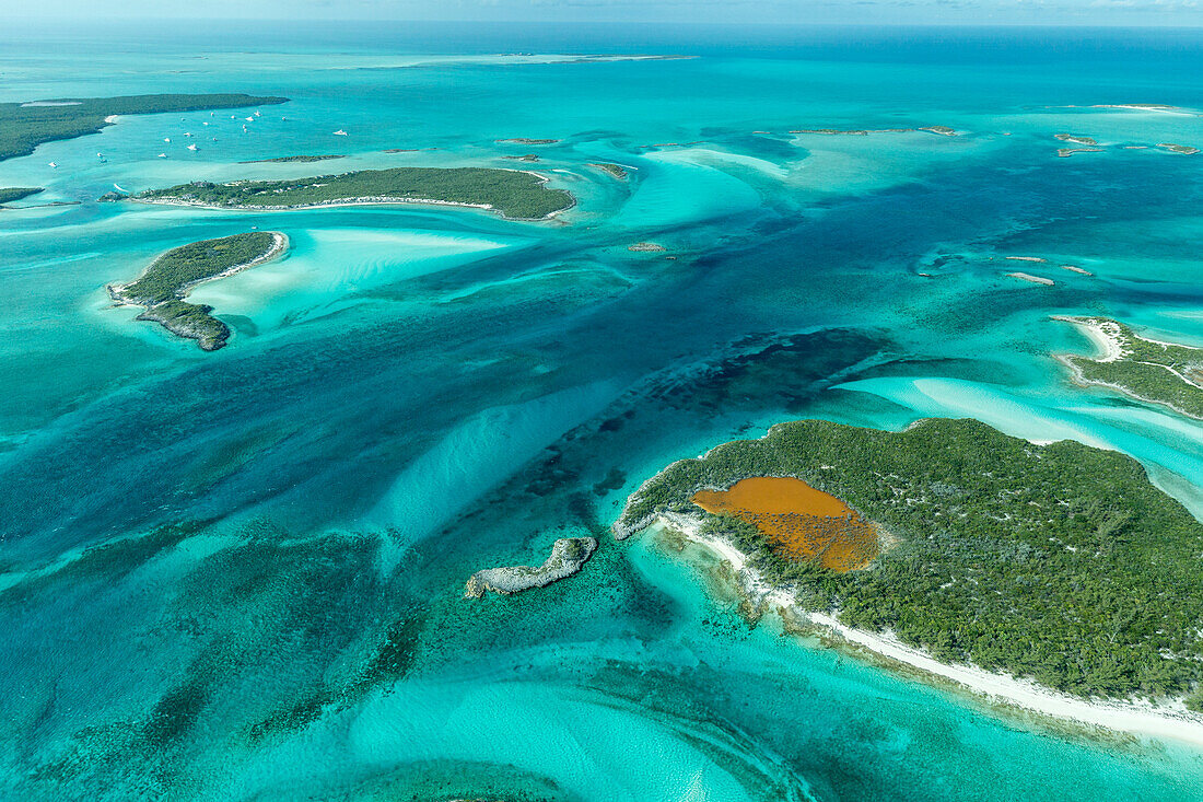 Luftbild mit Blick auf das klare tropische Wasser und die Inseln in der Exuma-Inselkette der Bahamas in der Nähe von Staniel Cay.