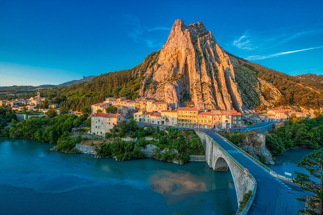 France, Provence, Sisteron. Mountain and bridge to town at sunset.