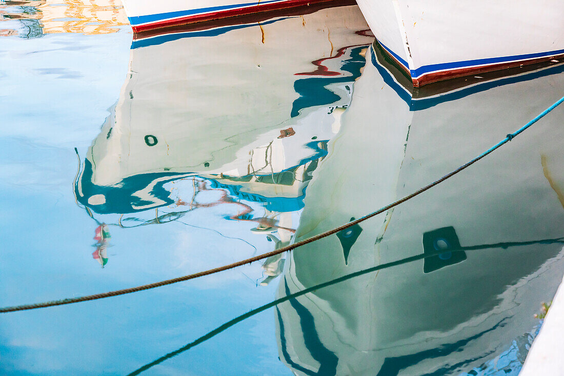 Italien, Sizilien, Provinz Agrigento, Sciacca. Spiegelung von Fischerbooten im Hafen von Sciacca am Mittelmeer.