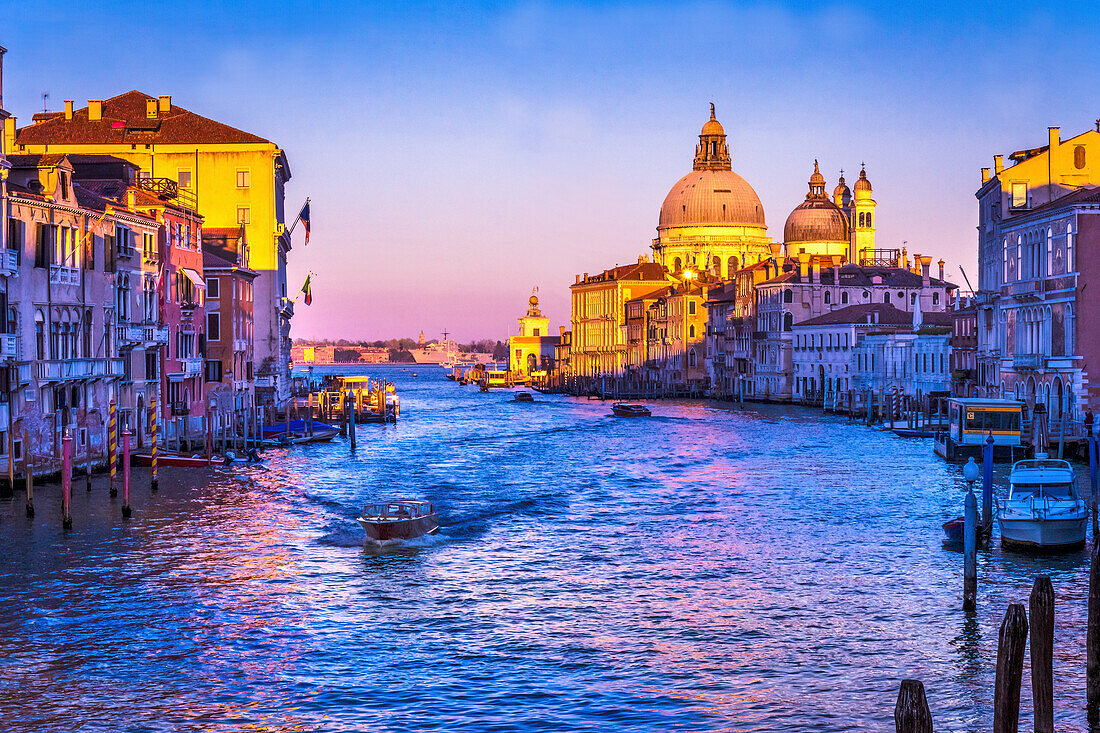Farbenfroher Canal Grande und die Kirche Santa Maria della Salute unter Sonnenuntergang mit Reflexion in Venedig, Italien.