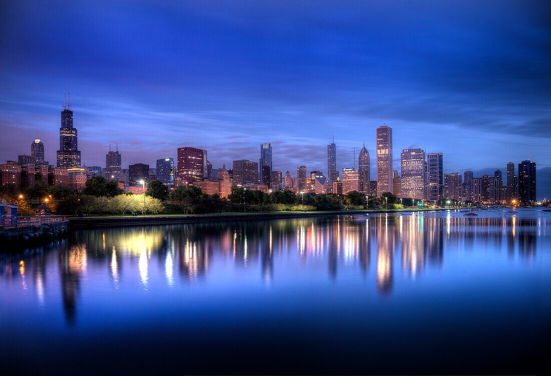 Chicago skyline reflects in lake Michigan during a blue sunrise