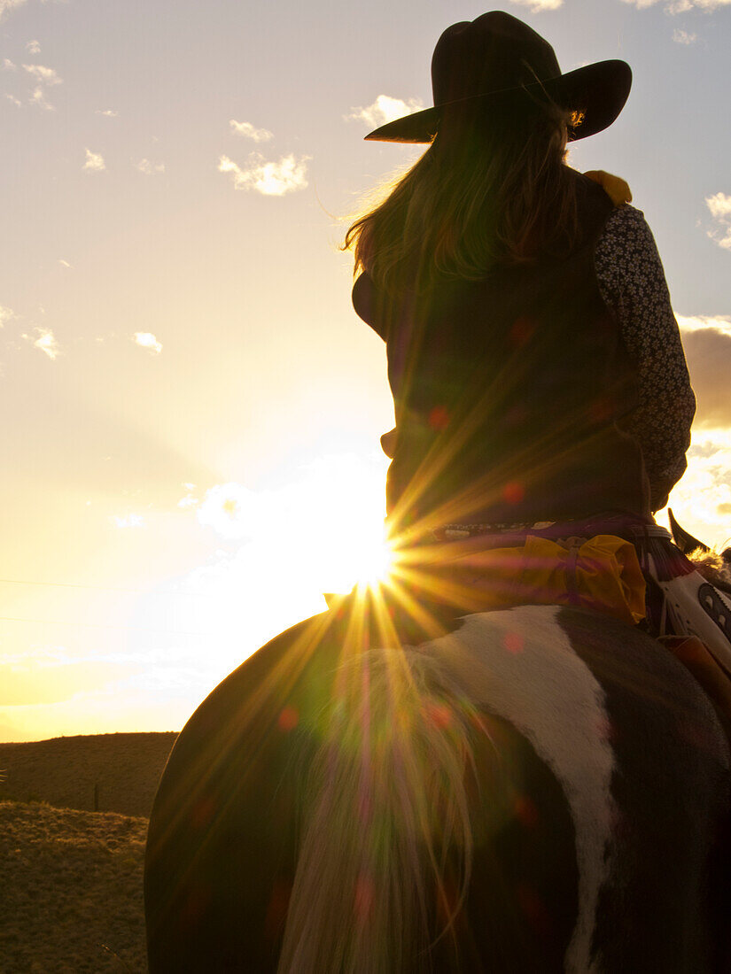 Nordamerika; USA; Wyoming; Shell; Big Horn Mountains; Cowgirl in Silouette mit Sonnenuntergang