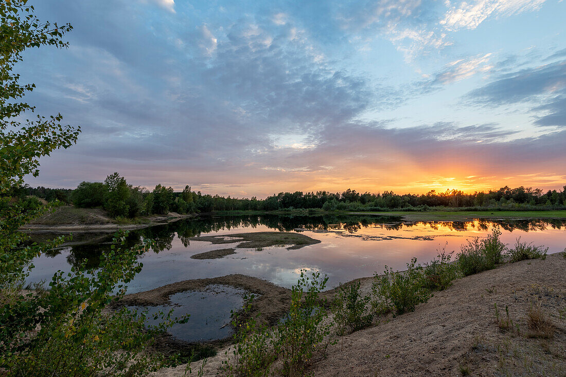 Sunset, clouds are reflected in a gravel pit, Hohenwarthe, Saxony-Anhalt, Germany