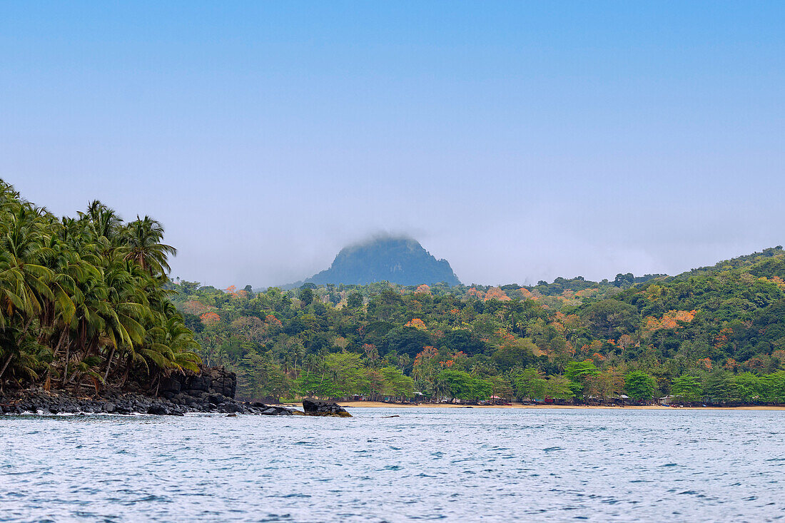 Nordküste mit Fischerdorf Praia das Burras und Strand und Blick auf Pico Papagaio auf der Insel Príncipe in Westafrika, Sao Tomé e Príncipe