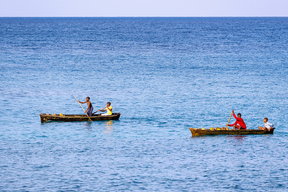 rudernde Kinder in Pirogenbooten mit Kokosnüssen vor der Insel Príncipe in Westafrika, Sao Tomé e Príncipe