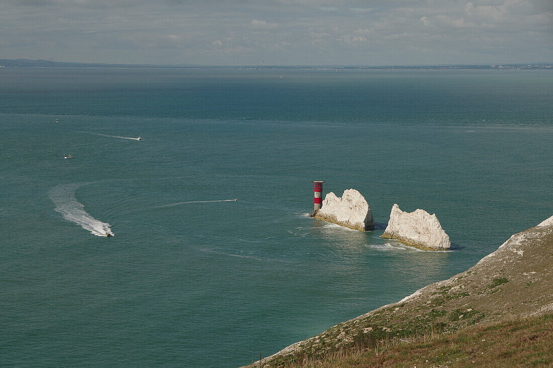 Blick auf die Needles auf der Isle of Wight bei Freshwater mit Leuchtturm und kleinen Booten auf dem Wasser, Südengland, England, Großbritannien, Europa