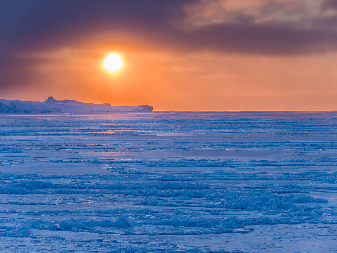 Sonnenuntergang im Winter am Ilulissat-Fjord in der Diskobucht in Westgrönland, der Fjord ist Teil des UNESCO-Weltkulturerbes.
